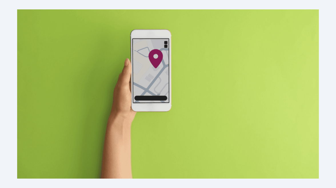 photo of a hand holding a smartphone with a screen showing a map with a pin