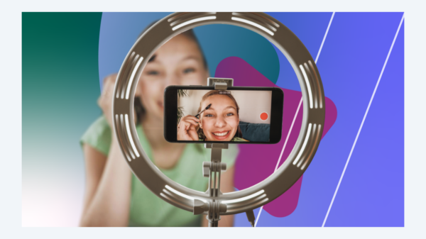 An image of a female teen doing a beauty routine video stream, as shown on the screen of a smartphone 